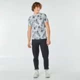 Remera blanca con estampado de hojas de palmera en tonos verde y azul.