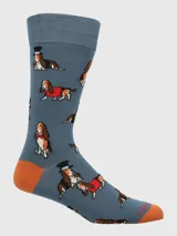 Calcetines de largo medio, color azul denim, con diseño estampado de perros Basset Hound en diversas poses y atuendos (con sombrero de copa, con moño rojo, con abrigo rojo). El talón y la punta son de color naranja quemado.