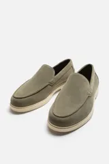 Mocasín casual de hombre color verde oliva, fabricado en cuero con acabado serraje, corte liso con detalle de bordón, horma redonda y suela a contraste color crema.