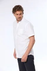 Camisa azul marino lisa de manga corta con cuello abotonado, cierre frontal con botones y bolsillo en el pecho. Confeccionada en algodón.