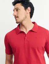 Chomba roja de piqué de algodón, con cuello polo y manga corta.