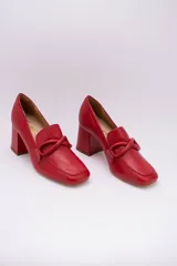 Zapato clásico de cuero azul marino, con aplique decorativo en el empeine y taco cuadrado.