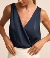 Body sin mangas color azul marino, confeccionado en tejido satinado, con escote en V cruzado en el frente y en la espalda.