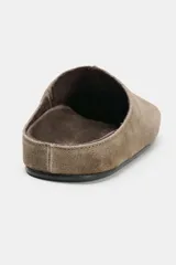 Zapato plano tipo mule destalonado confeccionado en serraje color marrón, con detalle de pespunte en el cuerpo y punta redonda.