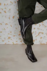 Botas Chelsea de cuero color marrón con elástico lateral negro, puntera metálica cuadrada y suela track.