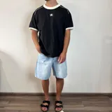 Remera negra de corte regular con cuello redondo y ribetes en contraste color blanco en el cuello y los puños. Presenta un pequeño logo bordado en el pecho.