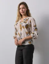 Blusa de gasa verde con estampado floral blanco y celeste, cuello a la base con escote en V y mangas 3/4 fruncidas.