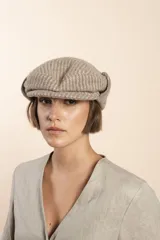 Boina con visera y orejeras de lana color beige con diseño de espiga.