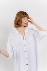 Vestido camisero midi color verde militar, confeccionado en lino 100%. Tiene cuello camisero, botones frontales y mangas 3/4 con botón para ajustar. Presenta silueta oversize y aberturas laterales.