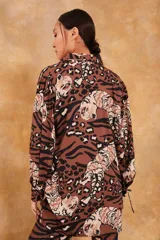 Camisa marrón con estampado de tigres y manchas de leopardo, de corte holgado y mangas largas.
