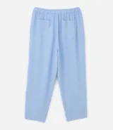 Pantalón de crepé celeste, modelo zanahoria, con elástico y lazo en la cintura. Presenta bolsillos traseros simples y bolsillos delanteros con solapas y botones metalizados.
