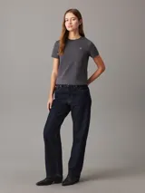 Remera gris de algodón con cuello redondo, mangas cortas y corte crop. Logo de Calvin Klein bordado en el pecho y estampado en la espalda.