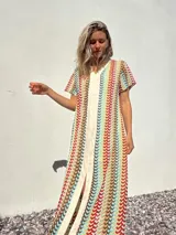 Vestido largo de tejido de punto con rayas verticales multicolores y abertura frontal.