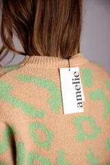 Sweater de punto color crudo con estampado animal print marrón.