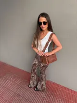 Cartera bandolera de cuero color marrón, con correa ajustable y bolsillo externo con cierre.