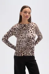 Sweater de tejido de punto, color crema, con estampado floral en tonos rosados y marrones. Presenta cuello redondo y mangas largas.