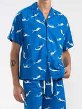 Short de baño azul con estampado de sirenas, cintura elástica y cordón de ajuste.