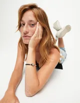 Pulsera semirígida de aleación de metales bañada en plata de ley con cuero marrón y una cuenta esférica plateada.