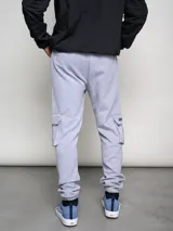 Pantalón de jogging gris con bolsillos cargo laterales y logo de la marca bordado en la pierna.