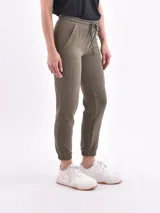 Pantalón deportivo tipo cargo de color verde militar, con cintura elástica ajustable con cordón y puños ajustados en los tobillos. Presenta bolsillos laterales tipo parche en la parte superior y bolsillos cargo a la altura de los muslos.