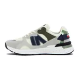 Championes deportivos Austral modelo Ushuaia, con combinación de colores gris claro, blanco hueso, azul marino y verde oliva. Presentan paneles de malla y gamuza sintética, y una suela blanca con detalles salpicados en negro.