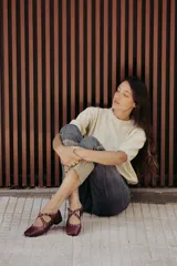 Sweater color dorado de tejido de punto suave con hilos metalizados, corte recto y mangas cortas con puño ajustado.