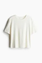 Remera color crudo de punto fino, con cuello redondo y mangas cortas.
