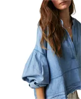 Blusa celeste de denim, manga larga abullonada, escote en V y corte holgado.
