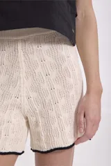 Short tejido de punto color crudo con borde negro.