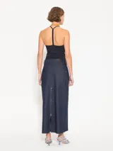 Pollera larga de denim azul oscuro, corte recto, tiro bajo, bolsillos ojal delanteros y tajo trasero con cierre.