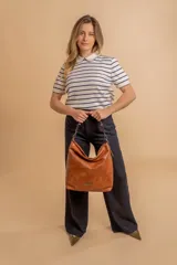 Cartera bandolera color marrón claro, de símil cuero, con dos divisiones internas, asa corta fija y correa larga regulable.