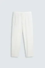 Pantalón blanco de algodón con textura, corte relaxed fit, cintura elástica ajustable con cordón, bolsillos laterales y traseros de vivo.