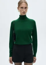 Sweater verde esmeralda de tejido de punto fino con cuello alto.