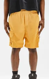 Bermuda cargo color mostaza de corderoy liviano, con bolsillos amplios con solapa, fuelle y detalles en cinta gross, elástico en la cintura y calce oversize.