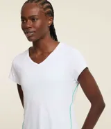 Remera deportiva blanca de microfibra, con cuello en V, mangas cortas y friso verde en la espalda.