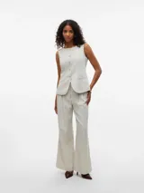 Pantalón sastrero de corte wide leg color beige, tiro medio, con bolsillos laterales, presillas para cinturón y detalle de pliegues en el frente.