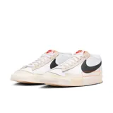 Championes Nike Blazer Low Pro Club para hombre, color blanco con detalles en negro y naranja.