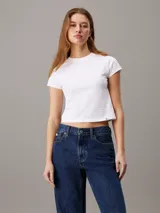 Remera blanca de algodón, corte slim y largo cropped, con cuello redondo y mangas cortas.