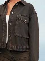 Campera de jean celeste con efecto lavado, corte cropped, cuello camisero, cierre frontal con botones metálicos, cuatro bolsillos frontales con solapa y puños abotonados.