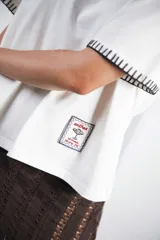 Remera azul marino de algodón con cuello redondo blanco y mangas cortas con bordado blanco.