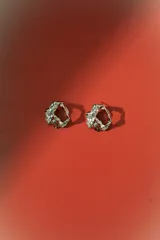 Aros de estilo orgánico, con forma irregular y textura martillada, en tono dorado.