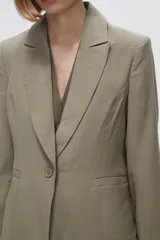Blazer color crudo de rayon, entallado, con cuello solapa y cierre con un botón.