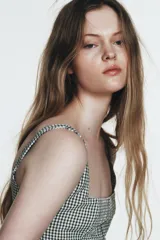 Vestido midi de tirantes con escote cuadrado y falda amplia con godets, confeccionado en tela con estampado de cuadros vichy en blanco y negro.