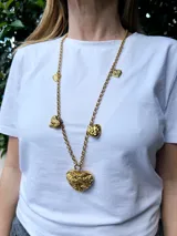 Collar largo dorado con cadena de eslabones y dijes de corazones texturizados.