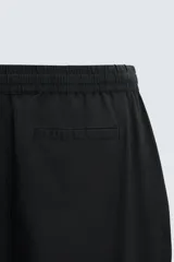 Pantalón azul marino de corte recto, con cintura elástica ajustable con cordón, bolsillos laterales y traseros.