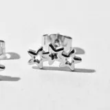 Caravanas de acero con diseño de estrellas, color plateado.