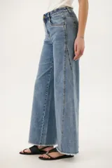 Pantalón de jean celeste de corte wide leg con terminación desflecada.