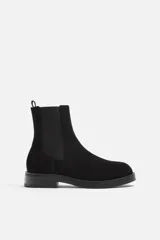 Bota Chelsea de cuero negro con elástico lateral, tirador trasero y suela con ligero tacón.