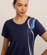 Remera deportiva blanca de microfibra texturizada, con cuello redondo, mangas cortas y estampa lateral de ondas en azul y fucsia.