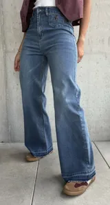 Jean de mujer color azul claro, de corte recto y tiro alto, con bolsillos delanteros decorativos con solapa y botón.